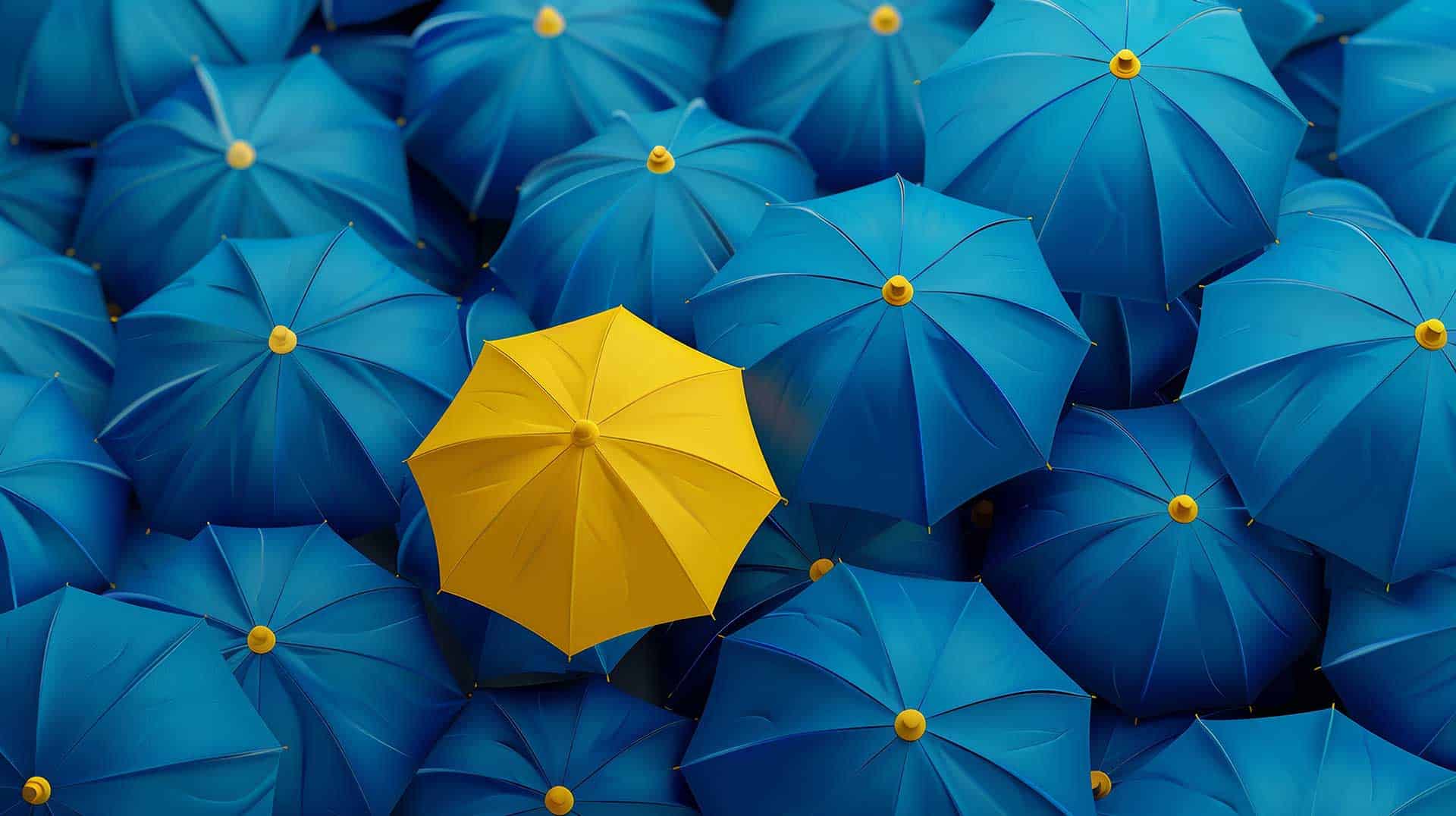 One yellow umbrella among many blue-teal umbrellas, seen from above